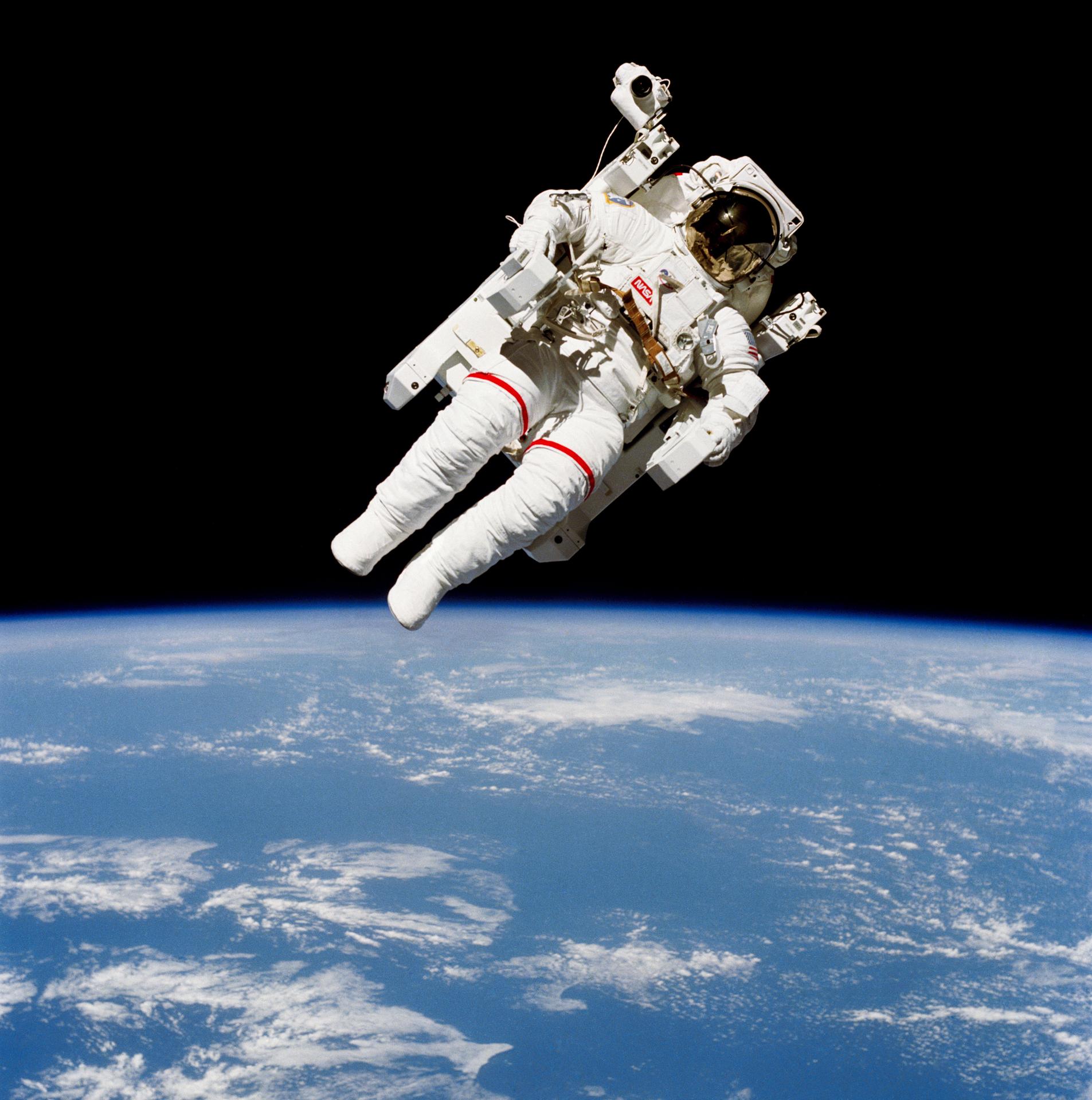 An astronaut floats in space untethered with Earth far below