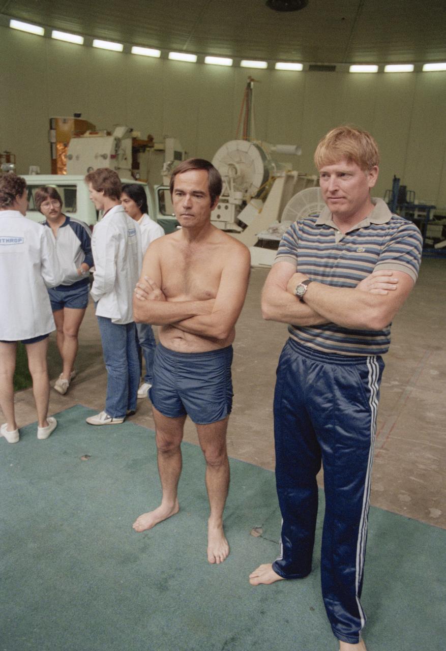 S84-36898 (29 June 1984) --- Astronauts Robert L. Crippen (left) and Jon A. McBride, crew commander and pilot, respectively for NASA's 41-G Space Shuttle mission, await the delivery of self contained underwater breathing apparatus (SCUBA) gear prior to their going underwater to observe a simulation of an extravehicular activity (EVA) scheduled for their mission.  The EVA will be performed by Astronauts Kathryn D. Sullivan and David C. Leestma, two of three mission specialists named for the seven-member crew.  The underwater training took place in the Johnson Space Center's weightless environment training facility (WET-F).