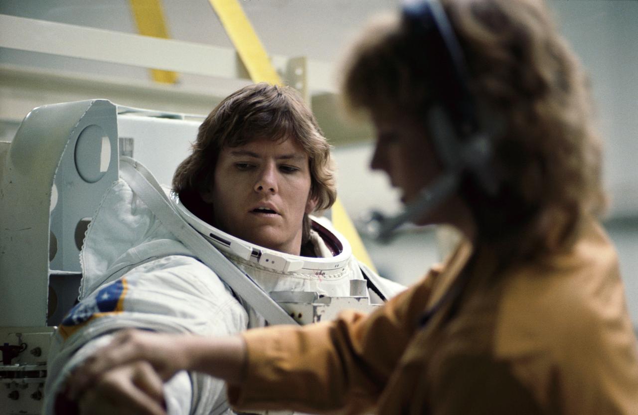 S84-36954 (5 July 1984) --- Astronaut Kathryn D.Sullivan, 41-G mission specialist, gets some   help with her extravehicular mobility unit (EMU) prior to participating in an underwater simultion of an extrvehicular activity (EVA) scheduled for her flight aboard the Columbia later this year. Dr. Sullivan and David C. Leestma (out of frame) participated in the rehearsal in NASA's weightless environment training facility (WET-F) at the Johnson Space Center.