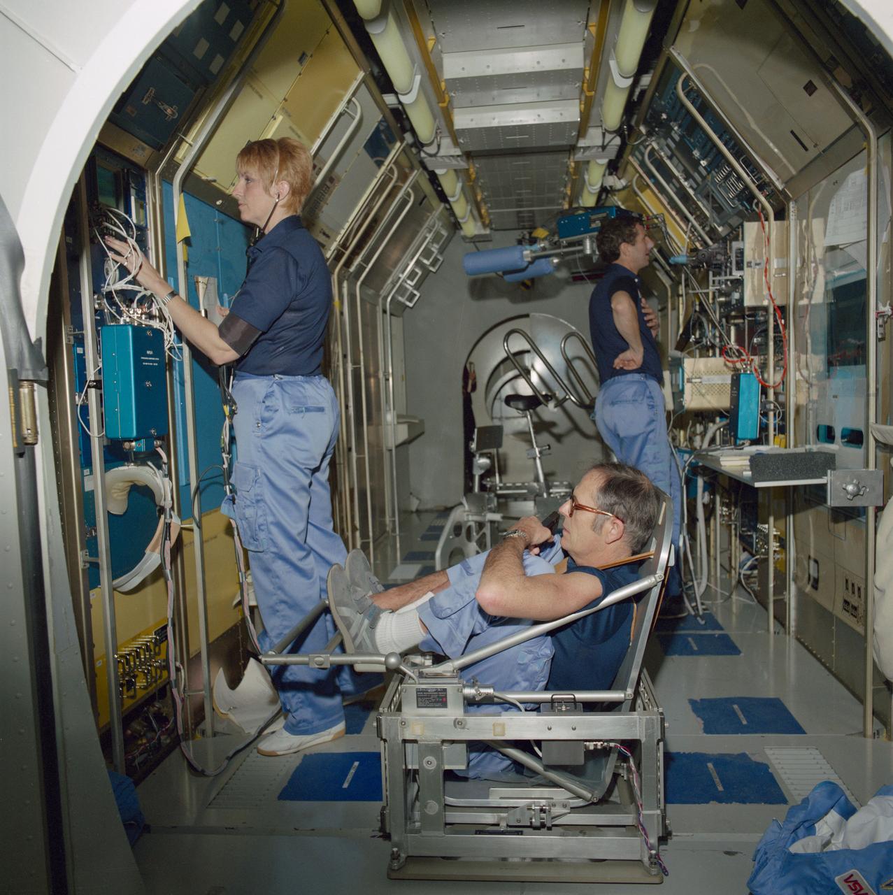 S85-26569 (Feb 1985) --- Two prime crew payload specialists (PS) for NASA's Space Life Sciences-1 (STS-40) mission and a backup PS rehearse medical experiments in a JSC trainer.  Left to right are Millie Hughes-Fulford, Robert Phillips and Drew Gaffney.  Hughes-Fulford and Gaffney are scheduled   to join five NASA astronauts for a Space Shuttle mission devoted to the study of life sciences.