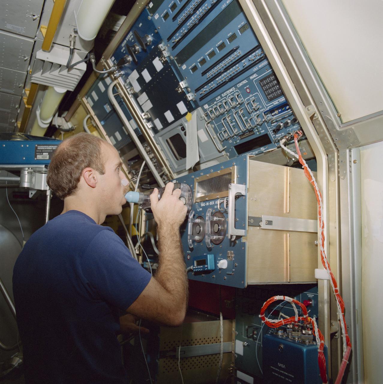 S85-26582 (Feb 1985) --- Training on the rebreathing assembly, astronaut James P. Bagian, STS-40 mission specialist, inhales a predetermined gas composition.  A gas analyzer mass spectrometer determines the composition of the gases he exhales.  The rebreathing assembly and gas analyzer system are part of an investigation that explores how lung function is altered. Dr. Bagian will be joined by two other mission specialists, the mission commander, the pilot and two payload specialists for the scheduled 10-day Spacelab Life Sciences-1 (SLS-1) mission.  The flight is totally dedicated to biological and medical experimentation.