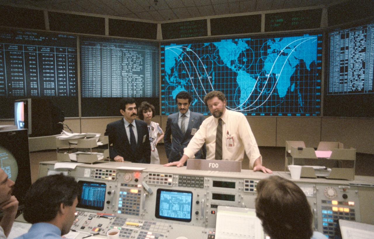 S85-29711 (April 1985) --- Ronald C. Epps, right of the training division in the mission operations directorate, briefs the Saudi Arabian payload specialist, Sultan Salman Abdelazize Al-Saud, and his backup, Abdulmohsen Hamad Al-Bassam, in the flight control room (FCR) of the mission control center (MCC). Erlinda Stevenson is also pictured.