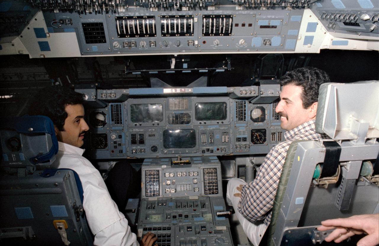 S85-29788 (May 1985) --- Sultan Salman Abdelazize Al-Saud and Abdulmohsen Hamad Al-Bassam man the controls on the flight deck of the crew compartment trainer (CCT) in the Shuttle mockup and integration laboratory at the Johnson Space Center (JSC).