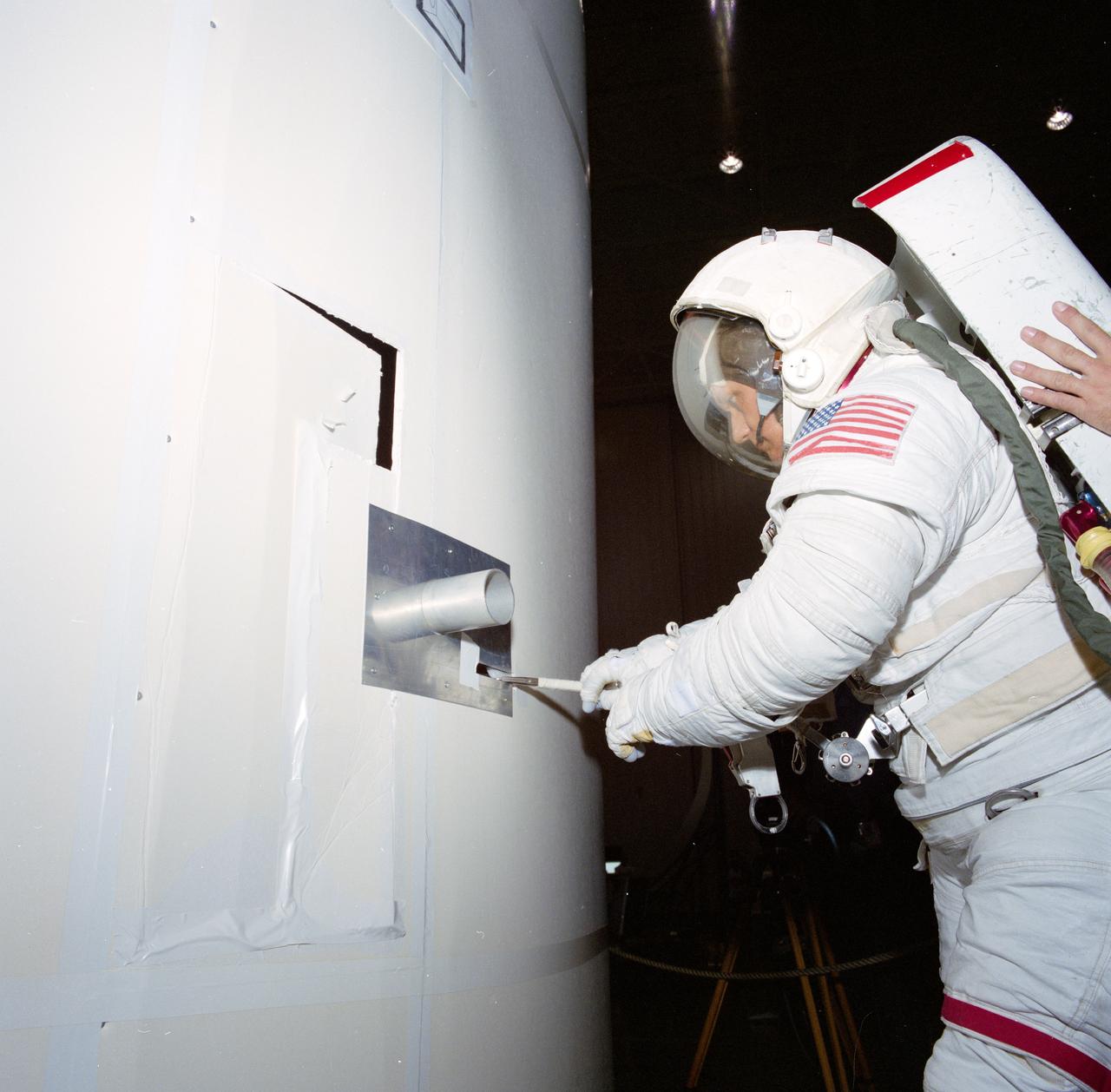 S85-30800 (14 April 1985) --- Astronaut Bruce McCandless II tests one of the possible methods of attempting to activate a switch on the Syncom-IV (LEASAT) satellite released April 13 into space from the Space Shuttle Discovery.  The communications spacecraft failed to behave properly upon release and NASA officials and satellite experts are considering possible means of repair.  McCandless was using a full scale mockup of the satellite in the Johnson Space Center's (JSC) mockup and integration laboratory.