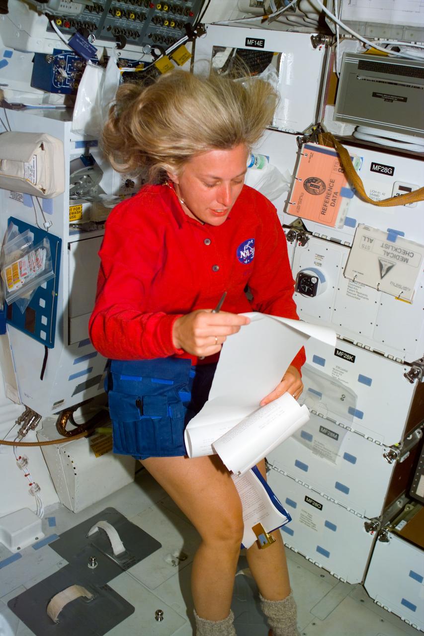 S85-E-5012 (10 August 1997) --- Astronaut N. Jan Davis, payload commander, looks at the mail from the Thermal Imaging Printing System (TIPS), on flight day four activities onboard the Space Shuttle Discovery.