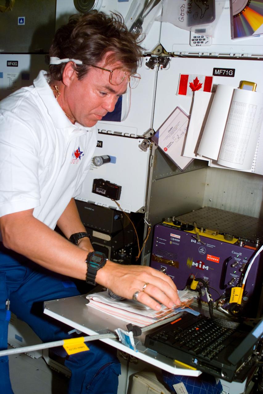 S85-E-5013 (10 August 1997) --- Bjarni V. Tryggvason, payload specialist representing the Canadian Space Agency (CSA), inputs data on a lap top during flight day four activities, onboard the Space Shuttle Discovery.
