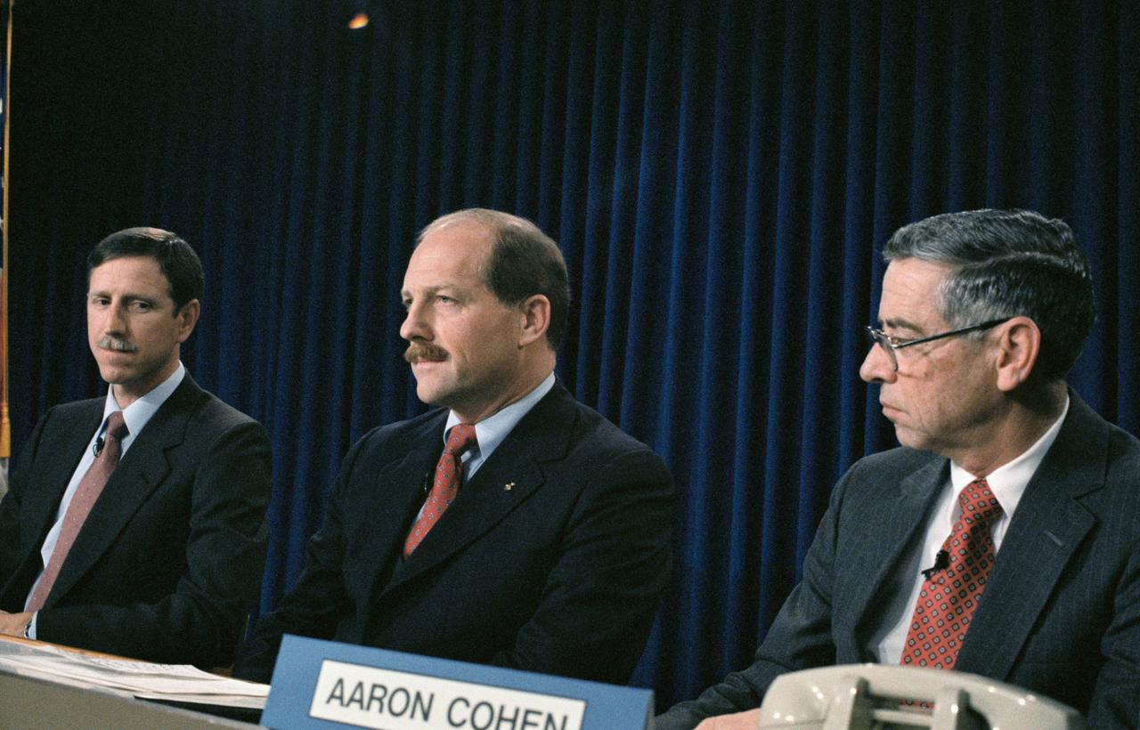 STS-26 Discovery, Orbiter Vehicle (OV) 103, crew including Commander Frederick H. Hauck and Pilot Richard O. Covey and JSC Director Aaron Cohen participate in press conference held at JSC Auditorium and Public Affairs Facility Bldg 2. Hauck and Covey are shown with Cohen as they ponder queries from news media representatives during the first press conference for the group since the mission's announcement last week. Left to right are Covey, Hauck, and Cohen.