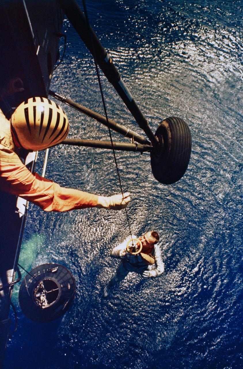 S88-31376 (5 May 1961) --- Astronaut Alan B. Shepard Jr., pilot of the Mercury-Redstone 3 (MR-3) suborbital spaceflight, is retrieved by a helicopter from the USS Lake Champlain during recovery operations in the western Atlantic Ocean. Shepard and the Mercury spacecraft designated the ?Freedom 7? (floating in water below) were flown to the deck of the recovery ship within 11 minutes of splashdown. MR-3 was the United States? first manned space mission.  The spacecraft attained a maximum speed of 5,180 miles per hour, reached an altitude of 116 1/2 statute miles, and landed 302 statute miles downrange from Cape Canaveral, Florida. The suborbital mission lasted 15 minutes and 22 seconds. Photo credit: NASA or National Aeronautics and Space Administration