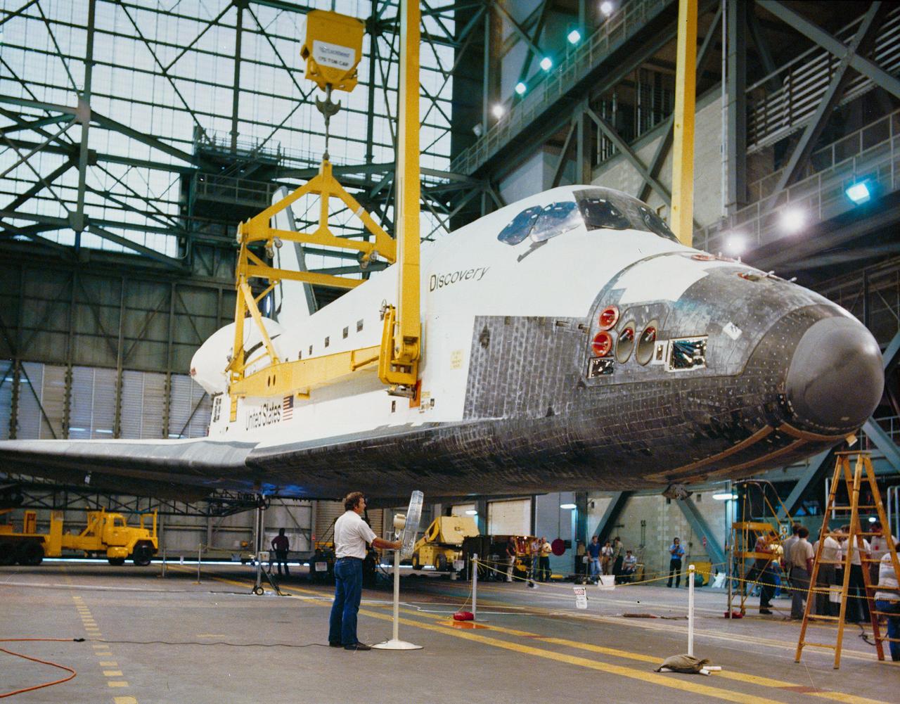 S88-41541 (7 July 1988) --- STS-26 Discovery, Orbiter Vehicle (OV) 103, is suspended by overhead crane and large frame attached to vehicle at four points. A ground-level view shows OV-103 during operations to accomplish its mating to two solid rocket boosters (SRBs) and an external fuel tank (ET) in the vehicle assembly building (VAB) at the Kennedy Space Center (KSC). From this step OV-103 will be lifted vertically and hoisted high inside the VAB for mating with the already connected ET and SRBs. In less than two weeks, the combined components will be rolled to Pad 39B atop a mobile launch platform.