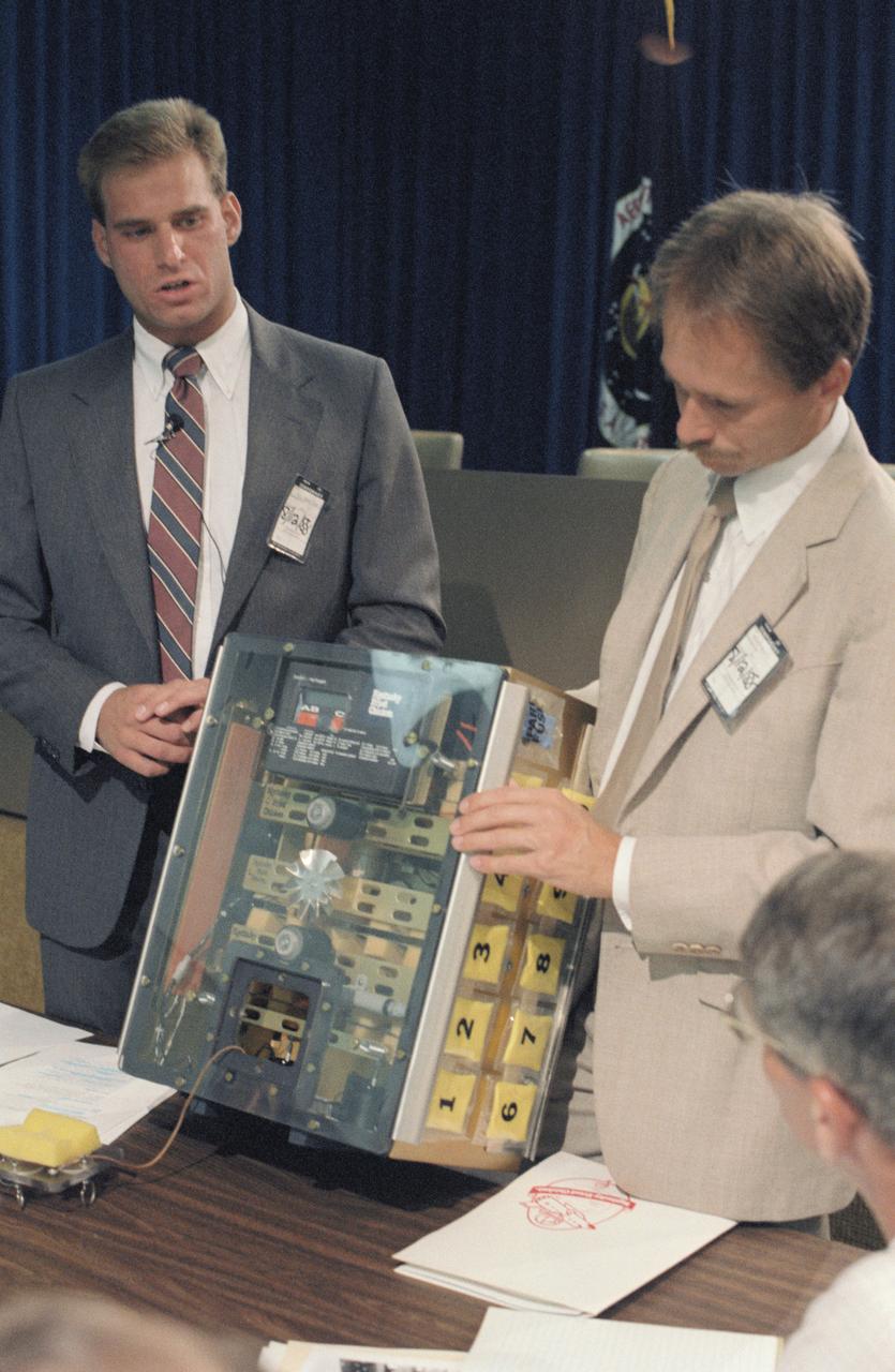S88-44514 (13 Aug  1988) ---  Student experimenter John C. Vellinger, left, explains components of an incubator used in his experiment to be carried onboard the Discovery for NASA's STS-29 mission next year.  Mark S. Deusser, representing the sponsoring organization, holds up the incubator for inspection by members of the STS-29 crew who will monitor in-space operation of the experiment, titled "Chicken Embryo Development in Space."  Astronaut Robert C. Springer is partially visible in lower right foreground.  The student's sponsor is Kentucky Fried Chicken.