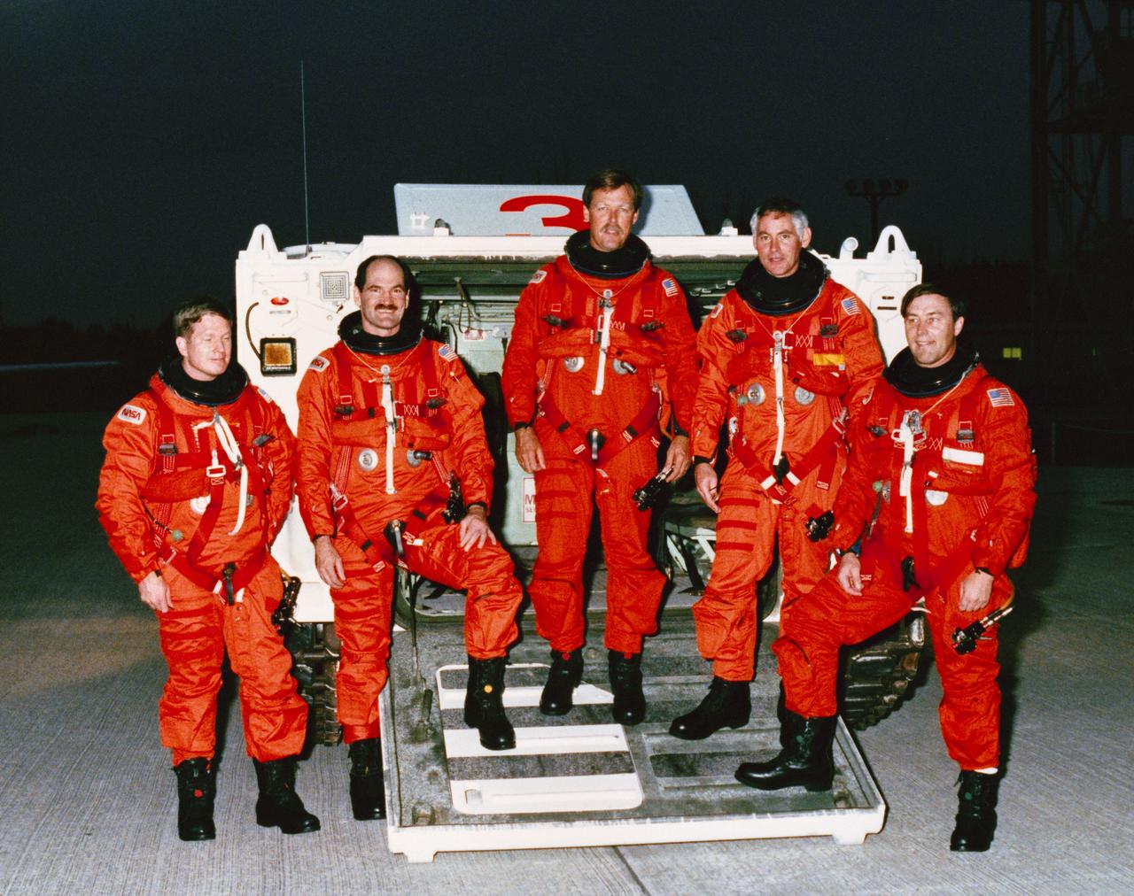 S88-53086 (17 Nov 1988) --- STS-27 Atlantis, Orbiter Vehicle (OV) 104, crewmembers participate in the terminal countdown demonstration test (TCDT) at the Kennedy Space Center (KSC). Standing in front of the M113 tracked rescue vehicle (armored personnel carrier (APC)) are left to right Mission Specialist (MS) William M. Shepherd, Pilot Guy S. Gardner, Commander Robert L. Gibson, MS Richard M. Mullane, and MS Jerry L. Ross. Crewmembers are wearing orange partial pressure or launch and entry suits (LES).