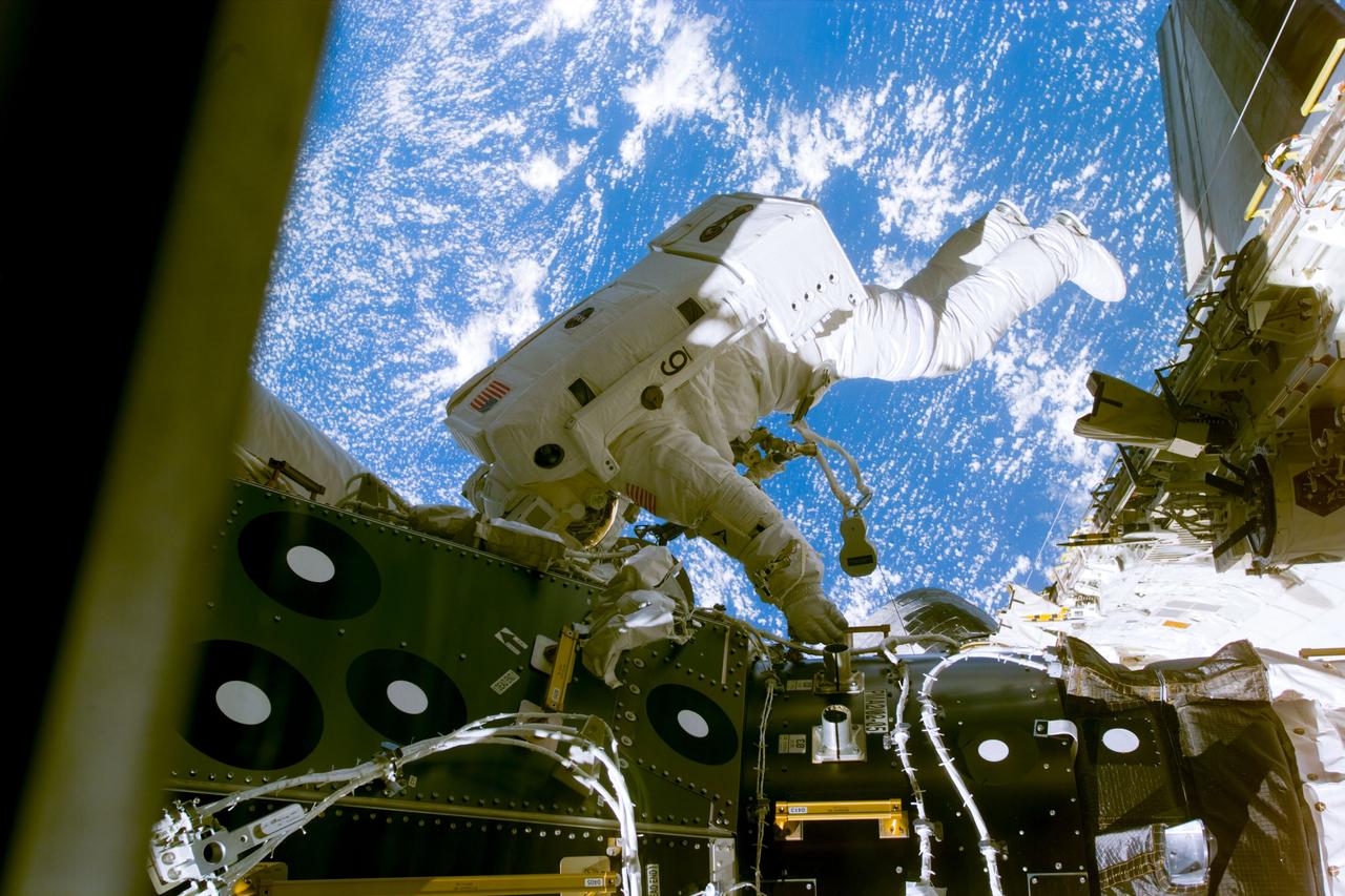 S88-E-5055 (12-07-98) --- Astronaut James H. Newman is seen at a pressurized mating adapter during early moments of the first of three scheduled spacewalks on STS-88.  Astronauts Newman and Jerry L. Ross, both mission specialists, went on to mate 40 cables and connectors running 76 feet from the Zarya control module to Unity, with the 35-ton complex towering over Endeavour;'s cargo bay. This photo was taken with an electronic  still camera (ESC) at 23:26:22 GMT, Dec. 7.