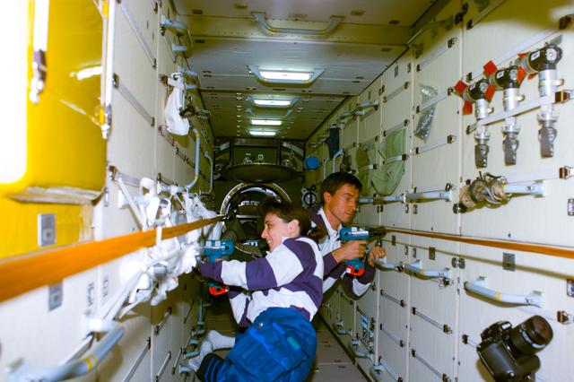 NASA image: Currie and Krikalev remove launch restraint bolts in FGB/Zarya module