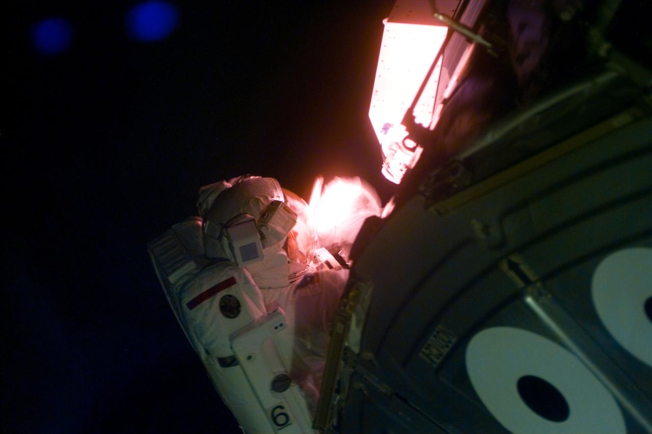 S88-E-5093 (12-09-98) --- Astronaut Jerry L. Ross, mission specialist, requires artificial light to work during the second STS-88 space walk.  Part of a pressurized mating adapter (PMA) is in the foreground.  The photo was taken with an electronic still camera (ESC) at  23:49:36 GMT, Dec. 9.