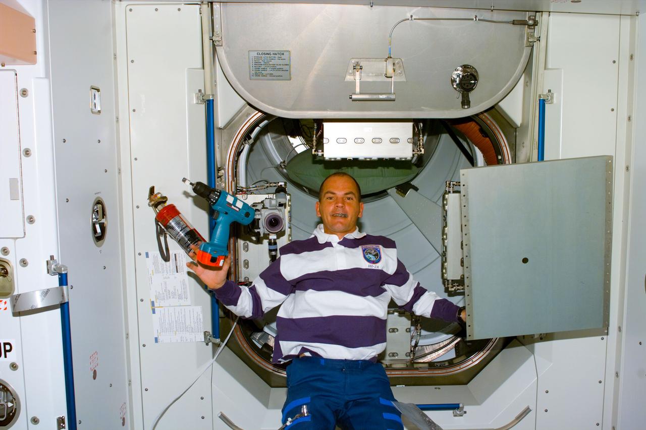 S88-E-5126 (12-11-98) --- Astronaut Frederick W. Sturckow, pilot, is pictured with a power tool near the hatchway between Unity and a pressurized mating adapter (PMA).  Members of the STS-88 crew used this type tool and others to attach handrails and accessories and perform other tasks on  Unity. The photo was taken with an electronic still camera (ESC) at 01:09:40 GMT, Dec. 11.