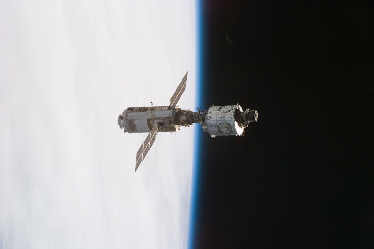 S88-E-5157 (12-13-98) --- The mated Russian-built Zarya (left, if the picture is held horizontally) and U.S.-built Unity modules are backdropped against the blackness of space and Earth's horizon shortly after leaving Endeavour's cargo bay. The photo was taken with an electronic still camera at 21:20:21 GMT, Dec. 13.