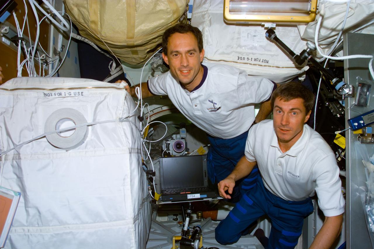 S88-E-5159 (12-14-98) --- Less than 48-hours prior to the completion of their 11-day mission in Earth orbit, two of the seven STS-88 crew members are pictured on Endeavour's middeck. They are James H. Newman (left) and Sergei K. Krikalev, both mission specialists.  Krikalev represents the Russian Space Agency (RSA) and has been named to the first ISS crew. Newman earlier had joined astronaut Jerry L. Ross on three space walks to perform a number of tasks to ready the first components of ISS.  The photo was taken with an electronic still camera (ESC) at 03:00:43, Dec. 14.