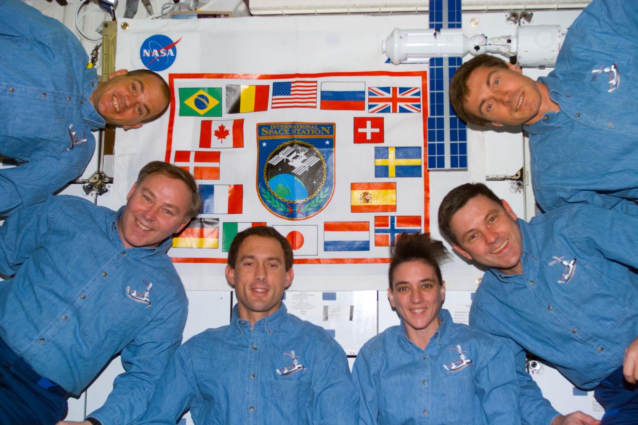 S88-E-5170 (12-15-98) --- A pre-set  electronic still camera (ESC) was used to take one of the traditional in-flight crew portraits for the STS-88 members on Endeavour's mid deck.  From the left  are Frederick W. (Rick) Sturckow, Jerry L. Ross, James H. Newman, Nancy J. Currie, Robert D. Cabana and Sergei K. Krikalev.  Krikalev, representing the Russian Space Agency (RSA), has been assigned as one of the crew members for the first ISS crew.  A banner representing the participating countries for ISS and a model (near Krikalev) of the connected Unity-Zarya modules are in the background.  The photo was taken at 00:12:48 GMT, Dec. 15.