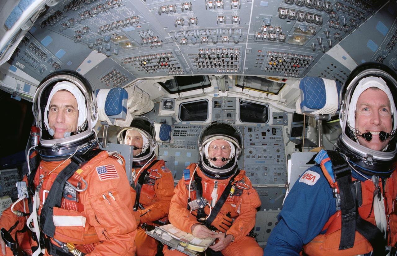 S89-26389 (Jan 1989) ---  Four of five crewmembers for STS-29 pause during launch and entry phase rehearsals in the crew compartment trainer at the Johnson Space Center.  The astronauts are in their entry positions, while the fifth (out of frame) remains strapped into a chair on the mid deck. In front are John E. Blaha (left), pilot, and Michael L. Coats, mission commander.  Behind them are James P. Bagian (left), and James F. Buchli, both mission specialists.  Robert C. Springer, the third mission specialist, is on the   mid deck. He will occupy Discovery's middeck for entry phase, while Bagian will occupy that post for launch.                Photo was made by Bill Bowers of the Johnson Space Center.
