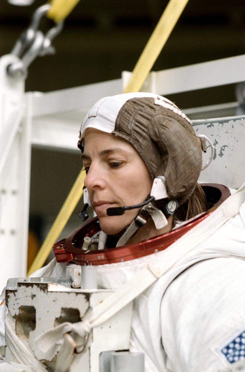 S89-41600 (Nov 1989) --- Astronaut Bonnie J. Dunbar, wearing an extravehicular mobility unit (EMU) spacesuit, prepares to don a helmet and be lowered by a hoist device for a session of underwater training in the Johnson Space Center's weightless environment training facility (WET-F).  Minutes later, Astronauts Dunbar and G. David Low, mission specialists, were neutrally buoyant in the nearby 25-ft. deep pool simulating a contingency extravehicular activity (EVA) for the scheduled December 1989 STS-32 mission.  There are no scheduled EVAs for the crew, whose main missions are to retrieve the Long Duration Exposure Facility (LDEF) and to deploy a Syncom satellite.