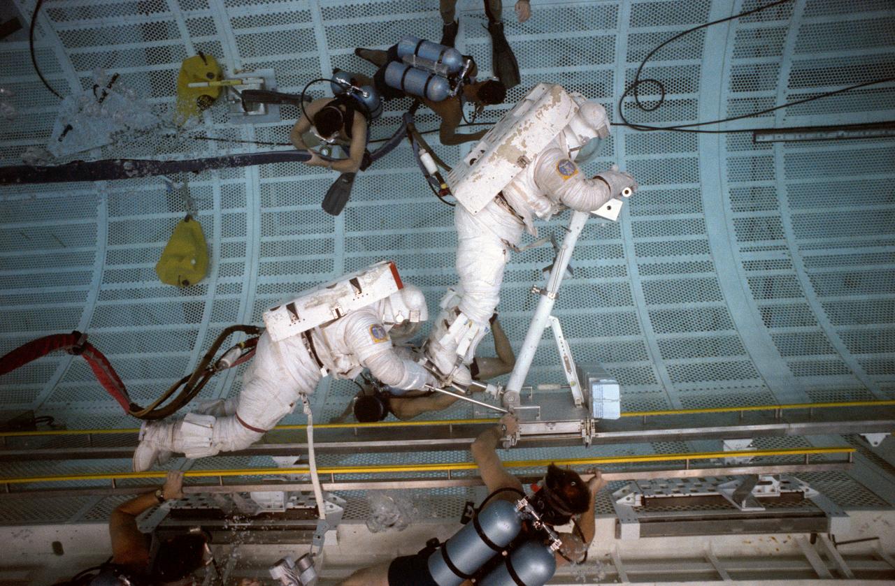 S89-46985 (October 1989) --- Astronauts Jerry L Ross and Jerome (Jay) Apt, STS-37 mission specialists, practice a spacewalk they will perform on that flight. The experiment uses an electrically powered version of the Crew and Equipment Translation Aid (CETA), a type of railroad handcart planned as a spacewalker's transportation system along the truss of Space Station Freedom. Apt is pulling Ross along to test the cart's ability to carry a person plus cargo.