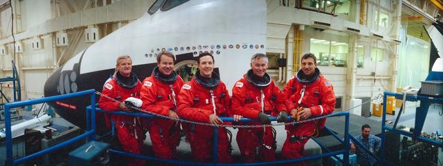 STS-36 crewmembers in LESs pose in front of JSC's crew compartment trainer