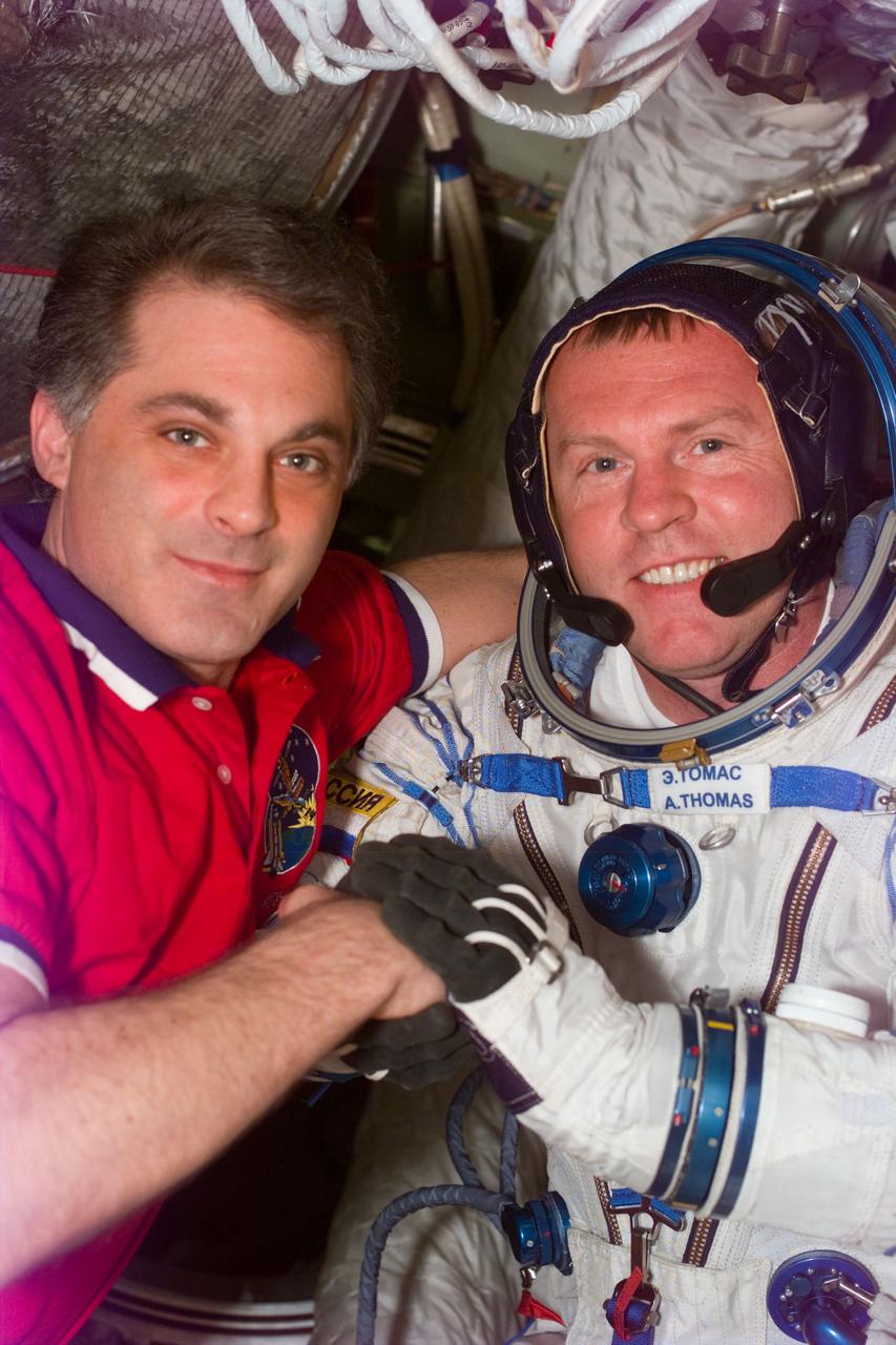 S89-E-5240 (26 Jan 1998) --- This Electronic Still Camera (ESC) image shows astronauts David A. Wolf and Andrew S. W. Thomas embracing, after Thomas' second Russian Sokol spacesuit test, onboard the Russian Mir Space Station.  Upon Thomas' arrival to Mir he had problems with his Sokol suit, however, following suit modifications the suit fit properly.  Thomas, now replacing Wolf as cosmonaut guest researcher, will be the last American astronaut to serve a tour onboard Mir.  This ESC view was taken on January 26, 1998, at 12:56:21 MET.