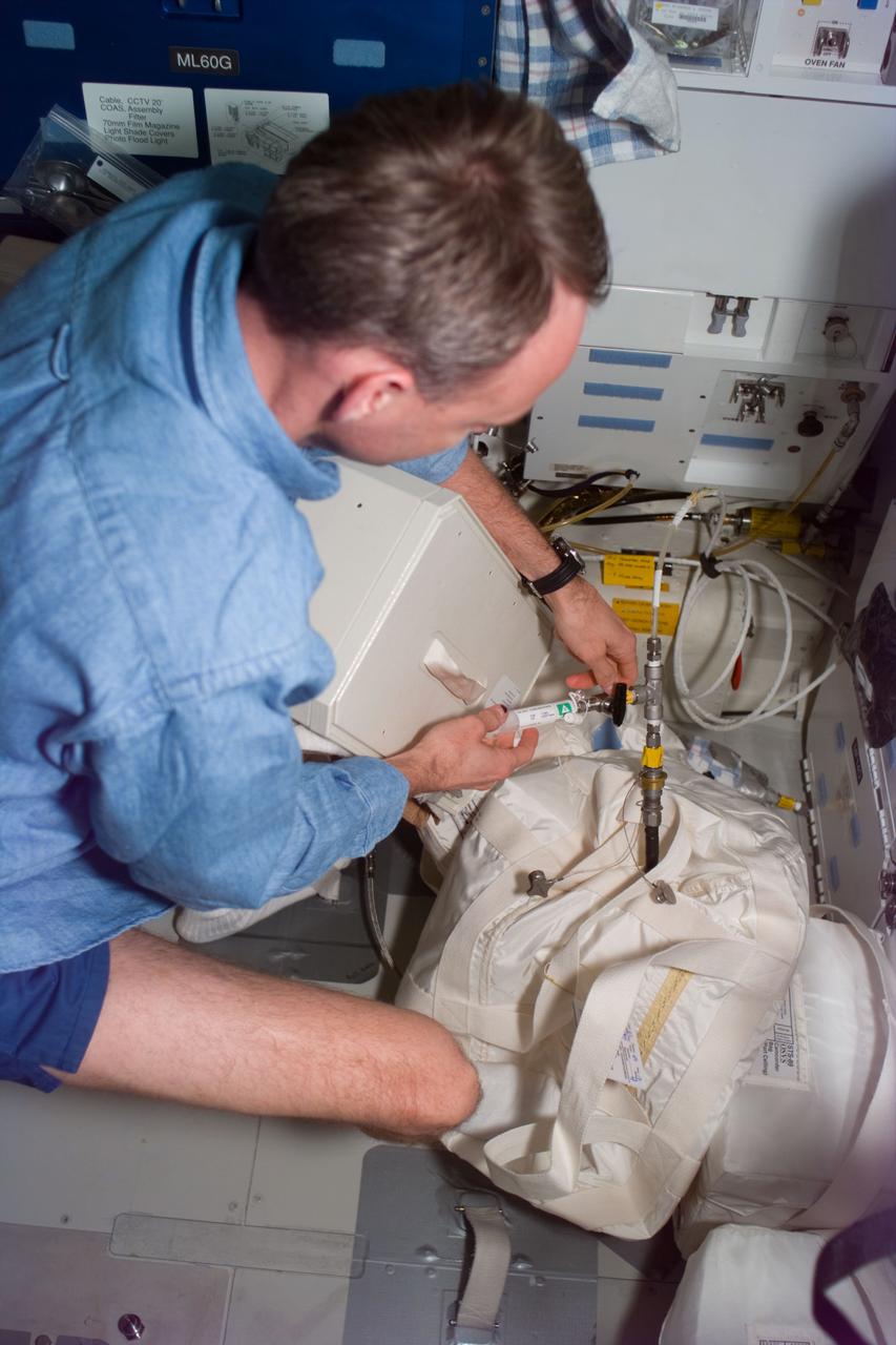 S89-E-5270 (25 Jan 1998) --- This Electronic Still Camera (ESC) image shows astronaut Joe F. Edwards, Jr., pilot, transferring fresh water from the Space Shuttle Endeavour to Russia's Mir Space Station during transfer operations. This ESC view was taken on January 25, 1998, at 08:30:49 MET.