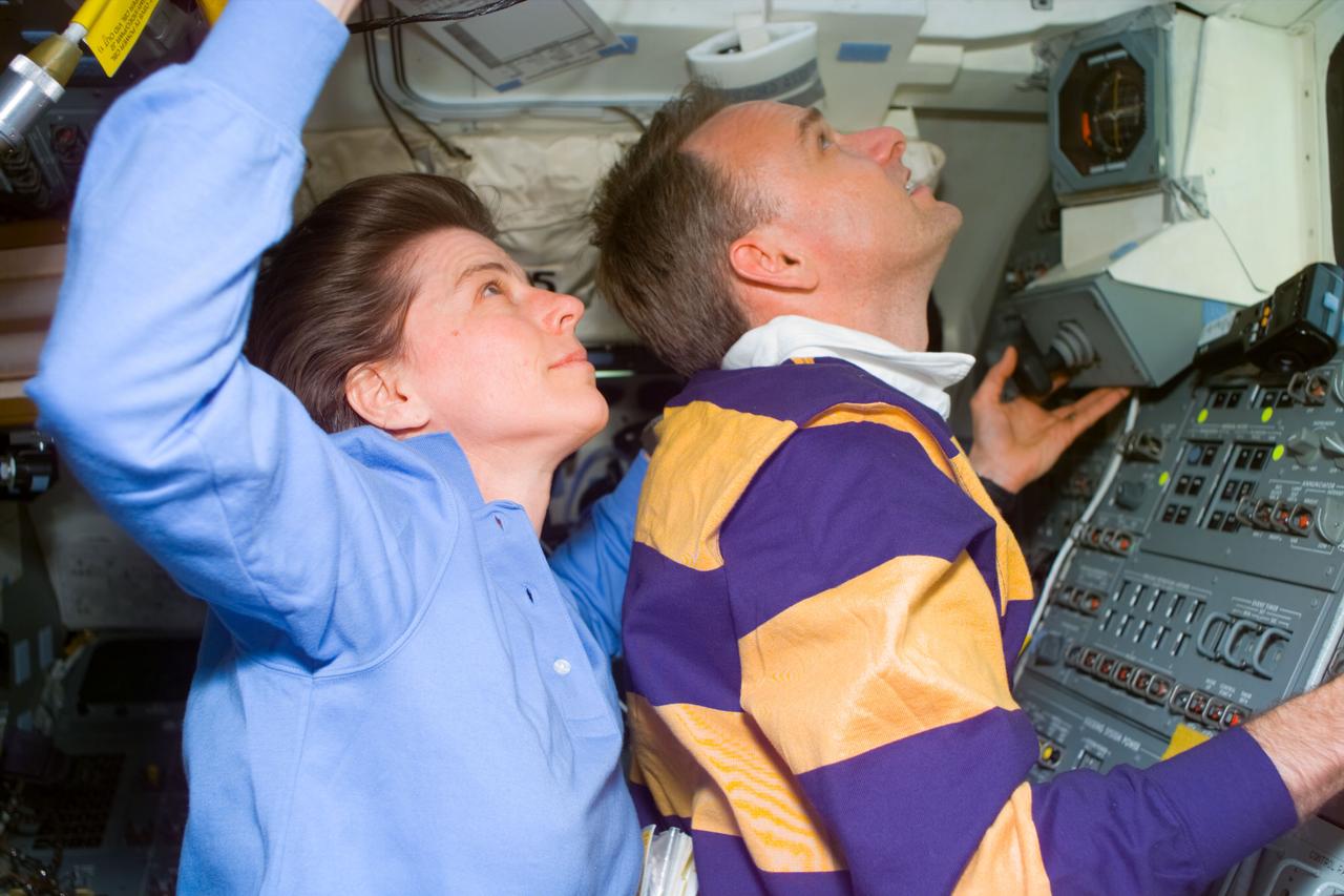 S89-E-5444 (29 Jan 1998) --- Astronauts Bonnie J. Dunbar, payload commander; and Joe F. Edwards, pilot; watch as Russia's Mir space station (out of frame) moves away from the Space Shuttle Endeavour following the undocking of the two spacecraft.  The photograph was taken with an electronic still camera (ESC) at 19:14:36 GMT, Jan. 29, 1998.