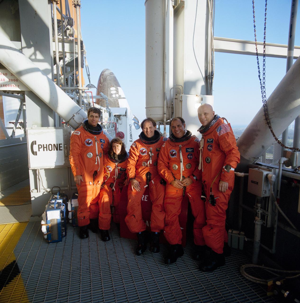 S90-27591 (23 Jan 1990) --- STS-33 crewmembers, wearing launch and entry suit (LES), take a break from training activities to pose for group portrait in front of Discovery, Orbiter Vehicle (OV) 103, at the 195 ft level elevator entrance at Kennedy Space Center (KSC) Launch Complex (LC) Pad 39B. Left to right are Pilot John E. Blaha, Mission Specialist (MS) Kathryn C. Thornton, MS Manley L. Carter, Jr, Commander Frederick D. Gregory, and MS F. Story Musgrave. Visible in the background is the catwalk to OV-103's side hatch.