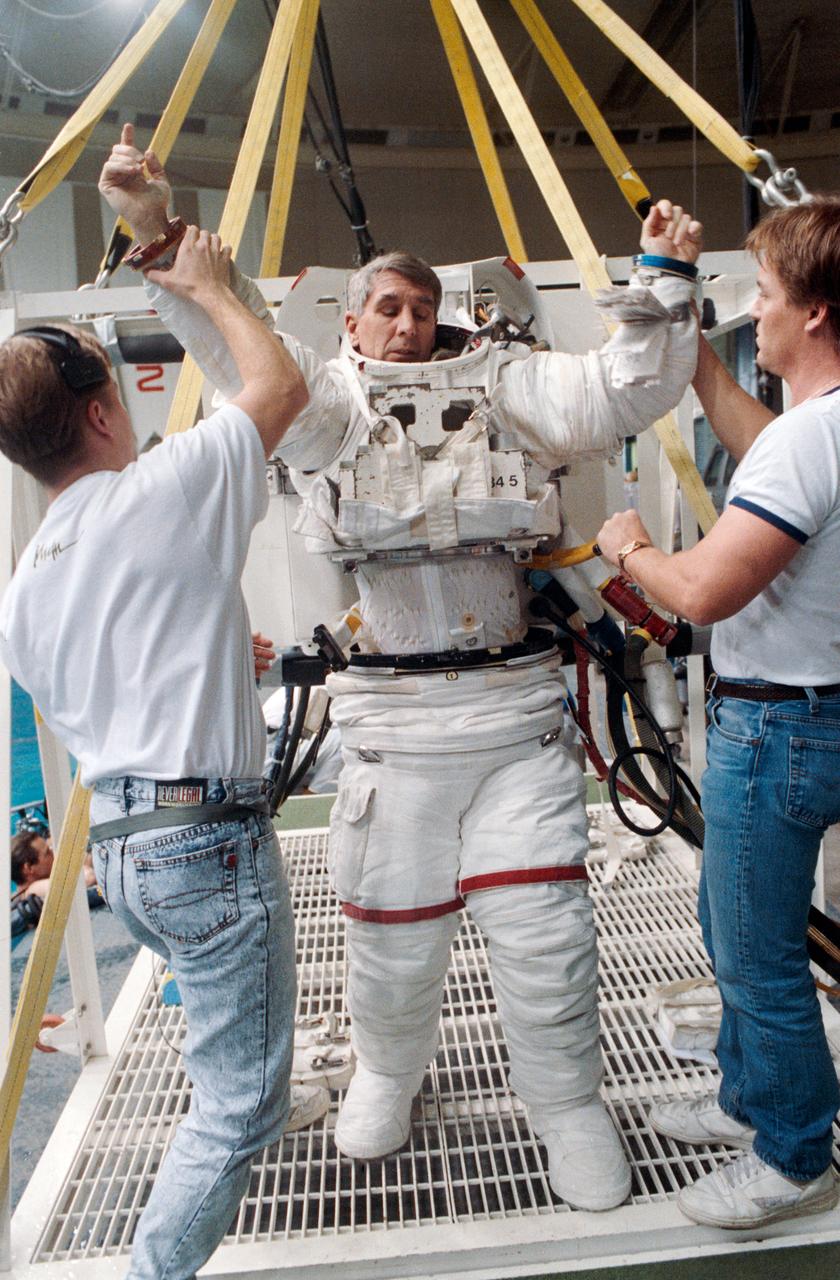 STS-38 ASTRONAUT CREW MEMBERS MEADE AND SPRINGER SUITING UP FOR AND ENTERING WETF TRAINING, TAKEN 02/14/90.