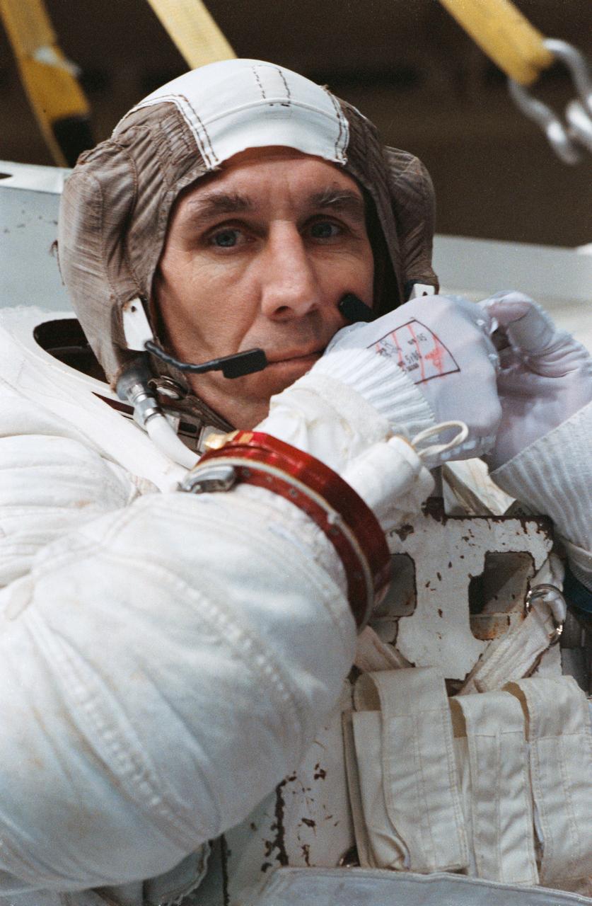 STS-38 Mission Specialist (MS) Robert C. Springer, wearing extravehicular mobility unit (EMU), fastens the strap on his communications carrier assembly (CCA) cap during suit donning in JSC's Weightless Environment Training Facility (WETF) Bldg 29. Positioned on the WETF platform at pool side, Springer is preparing for an underwater extravehicular activity (EVA) simulation. During the training exercise, Springer will rehearse contingency EVA procedures for the STS-38 mission aboard Atlantis, Orbiter Vehicle (OV) 104.