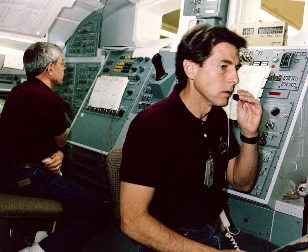 STS-35 Mission Specialist (MS) Robert A.R. Parker (left) and Payload Specialist Samuel T. Durrance practice Astronomy Laboratory 1 (ASTRO-1) experiment procedures in a space shuttle aft flight deck mockup in the Payload Crew Training Complex at the Marshall Space Flight Center (MSFC) in Huntsville, Alabama. For all Spacelab missions, shuttle crew members train regularly in the facility in preparation to operate experiments on their Spacelab missions. The ASTRO-1 crew will operate the ultraviolet telescopes and instrument pointing system (IPS) from Columbia's, Orbiter Vehicle (OV) 102's, aft flight deck. The seven-member ASTRO-1 crew will work around the clock, in 12-hour shifts, to allow the maximum number of observations to be made during their nine or ten days in orbit. In addition to the commander and pilot, the crew consistss of three MSs and two payload specialists. (MSs are career astronauts who are trained in a specialized field. Payload specialists are members of the science investigator teams who were nominated by their peers to operate their experiments on orbit. They are trained and certified for flight by NASA.) View provided by MSFC with alternate number 9005803.