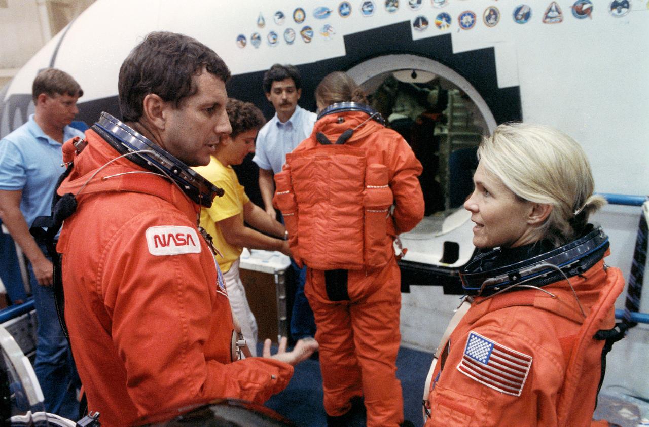 S90-41365 (11 June 1990) --- Crewmembers assigned to NASA's STS-40/Spacelab Life Sciences (SLS-1) mission take a brief break during emergency egress training in the Shuttle mockup and integration laboratory at   the Johnson Space Center (JSC).  In the foreground are astronauts Rhea Seddon and payload specialist F. Drew Gaffney. In the background, also wearing an orange partial pressure, ascent/entry suit is astronaut Tamara E. Jernigan, mission specialist. Not in the frame are astronauts Bryan D. O'Connor, mission commander; Sidney M. Gutierrez, pilot; James P. Bagian,  mission specialist, and payload specialist Millie Fulford-Hughes.