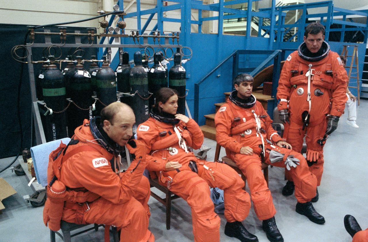 S90-41372 (11 June 1990) --- Crewmembers assigned to NASA's STS 40 Spacelab Life Sciences (SLS-1) mission take a brief break during emergency egress training in the Shuttle mockup and integration laboratory at   the Johnson Space Center (JSC).  Left to right are astronauts James P. Bagian, Tamara E. Jernigan, both mission specialists; and Sidney M. Gutierrez, pilot; and Bryan D. O'Connor, mission commander.  Out of frame are astronaut Rhea Seddon, mission specialist, and payload specialists Millie Hughes-Fulford and Drew Gaffney.