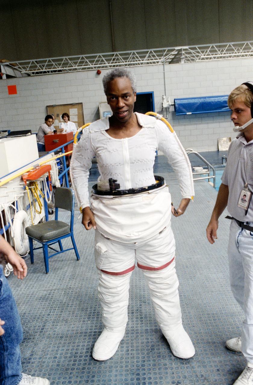 S90-44106 (August 1990) --- Astronaut Guion S. Bluford, mission specialist for STS-39, wearing part of an extravehicular mobility unit (EMU) spacesuit, prepares to participate in a training session for the scheduled   March 1991 spaceflight.  Soon after this picture was taken, Bluford was lowered into water by a hoist device for the underwater rehearsal of a contingency EVA.  The scene is in the Johnson Space Center's weightless environment training facility (WET-F) which houses a 25-ft. deep pool (visible in right background).