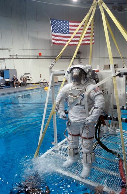 NASA image: STS-39 MS Bluford wearing EMU is lowered into JSC's WETF Bldg 29 pool