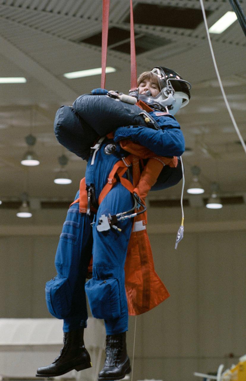 S90-45238 (25 June 1990) ---- Astronaut Linda M. Godwin, STS 37 mission specialist, simulates emergency egress from a Space Shuttle. The training session was held in the Johnson Space Center's (JSC) weightless environment training facility (WET-F). The 25-ft. pool in the facility served as a simulated ocean into which a parachute landing might be made. Early next year, Godwin, along with four other astronauts, will fly onboard Atlantis for a five-day mission.