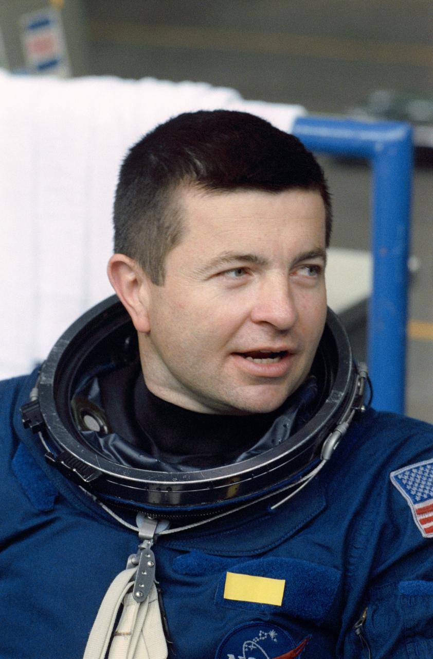 STS-37 Pilot Kenneth D. Cameron, wearing launch and entry suit (LES), discusses simulated emergency egress training on the pool side of JSC's Weightless Environment Training Facility (WETF) Bldg 29. Cameron will be dropped into a simulated ocean, the WETF's 25-ft pool, into which a parachute landing might be made.