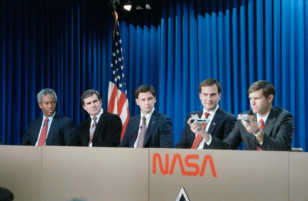 S91-26676 (23 Jan 1991) --- The five mission specialists assigned to the STS-39 Shuttle mission are pictured during a pre-flight press briefing.  Pictured left to right are Astronauts Guion (Guy) S. Bluford, C.  Lacy Veach, Gregory J. Harbaugh, Richard J. Hieb and Donald R. McMonagle.  McMonagle uses models to demonstrate deployment of the infrared background signature survey (IBSS) satellite. Astronauts Michael L. Coats, mission commander, and L. Blaine Hammond Jr.,  pilot, are out of frame at right.
