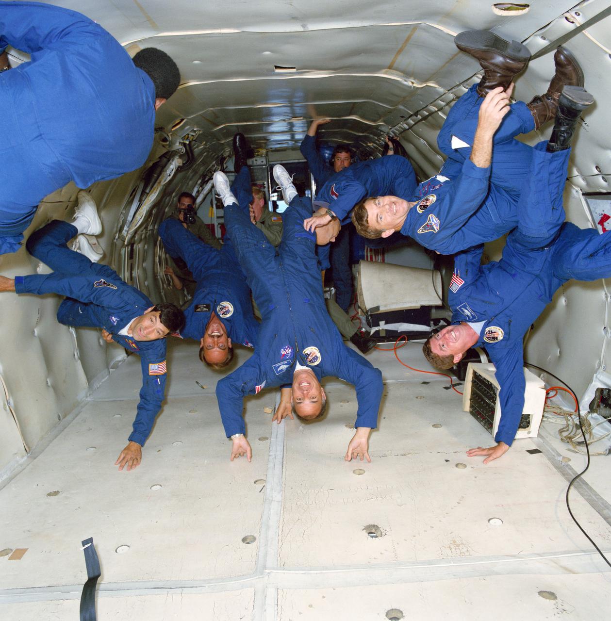 S91-38355  (28 May 1991) --- Seen floating about the vacant spaces of the Johnson Space Center's KC-135 "zero-gravity" aircraft are the six crewmembers for the STS 44 mission.  Left to right are Terence T.  Henricks, James S. Voss, F. Story Musgrave (partially obscured), Frederick D. Gregory, Thomas J. Hennen and Mario Runco Jr.  Gregory is mission commander.  Hennen is payload specialist for this flight, dedicated to the Department of Defense.  The flight served as a refresher and a preview of the experience of weightlessness, as the special aircraft flew a series of parabolas which provided short sessions of zero-gravity.