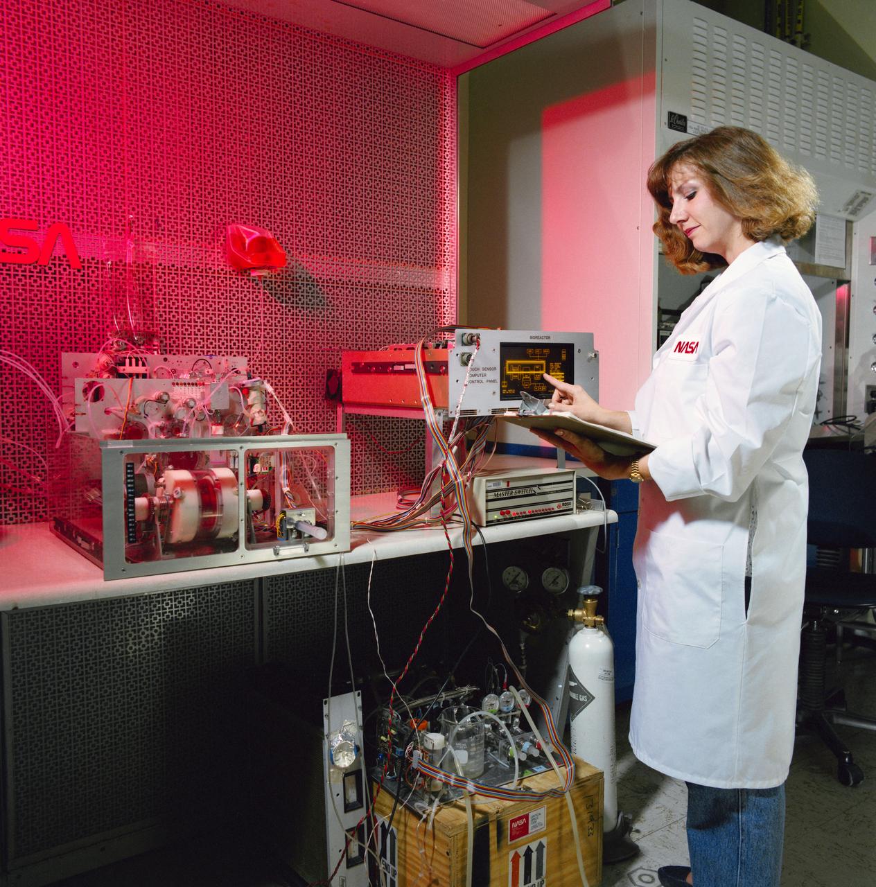 S91-40049   (27 June 1991) --- JSC technician Tacey Prewitt checks the progress on a bioreactor experiment in JSC's Life Sciences Laboratory Bldg 37 biotechnology laboratory. Similar hardware is scheduled for testing aboard Atlantis, Orbiter Vehicle (OV) 104, during STS-44. Detailed Supplementary Objective (DSO) 316 Bioreactor/Flow and Particle Trajectory in Microgravity will checkout the rotating wall vessel hardware and hopefully will confirm researchers' theories and calculations about how flow fields work in space. Plastic beads of various sizes rather than cell cultures are being flown in the vessel for the STS-44 test.