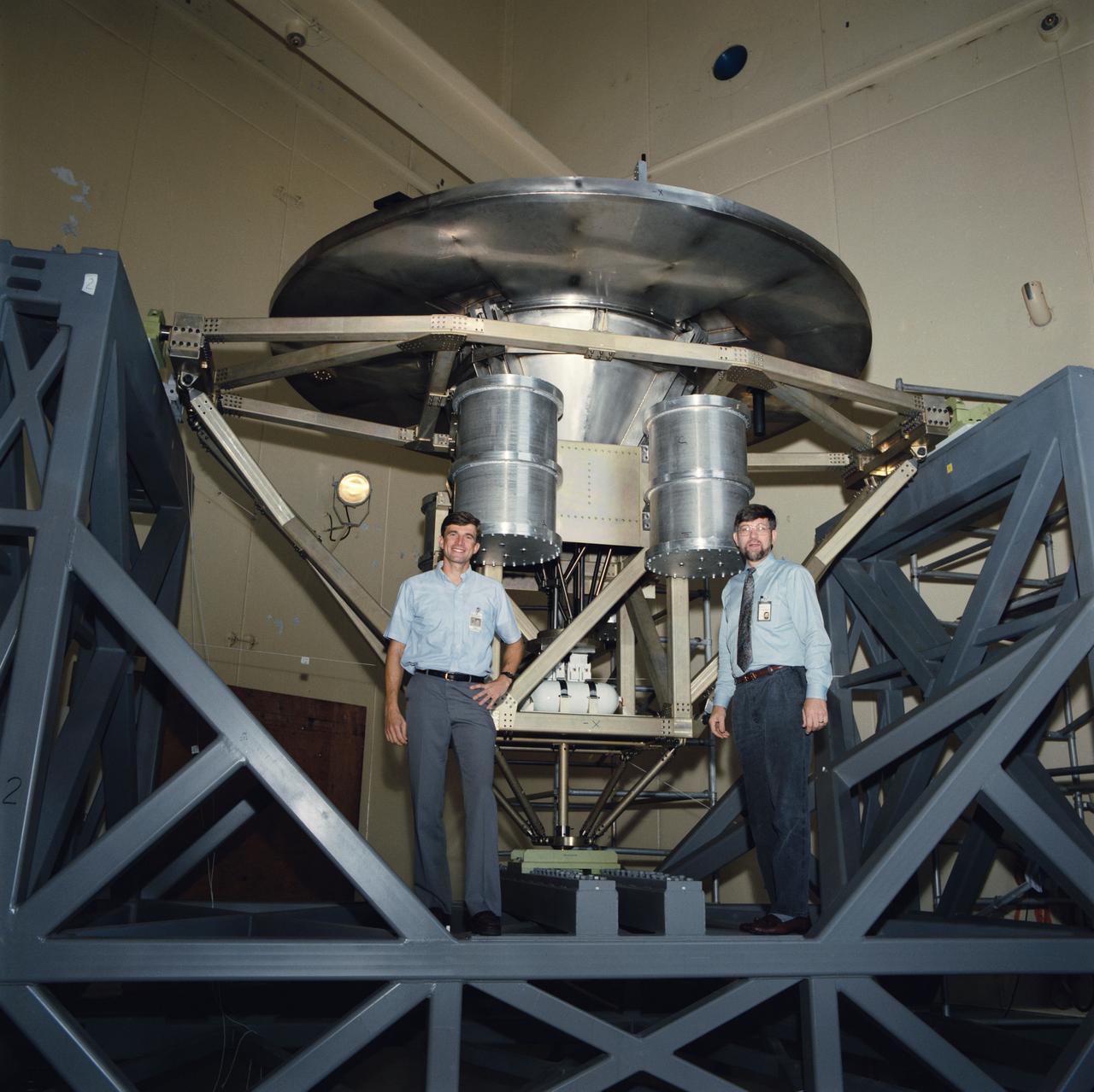 The Wake Shield Facility is displayed on a test stand at JSC. Astronaut Ronald M. Sega, mission specialist for STS-60, is seen with the facility during a break in testing in the acoustic and vibration facility at JSC.