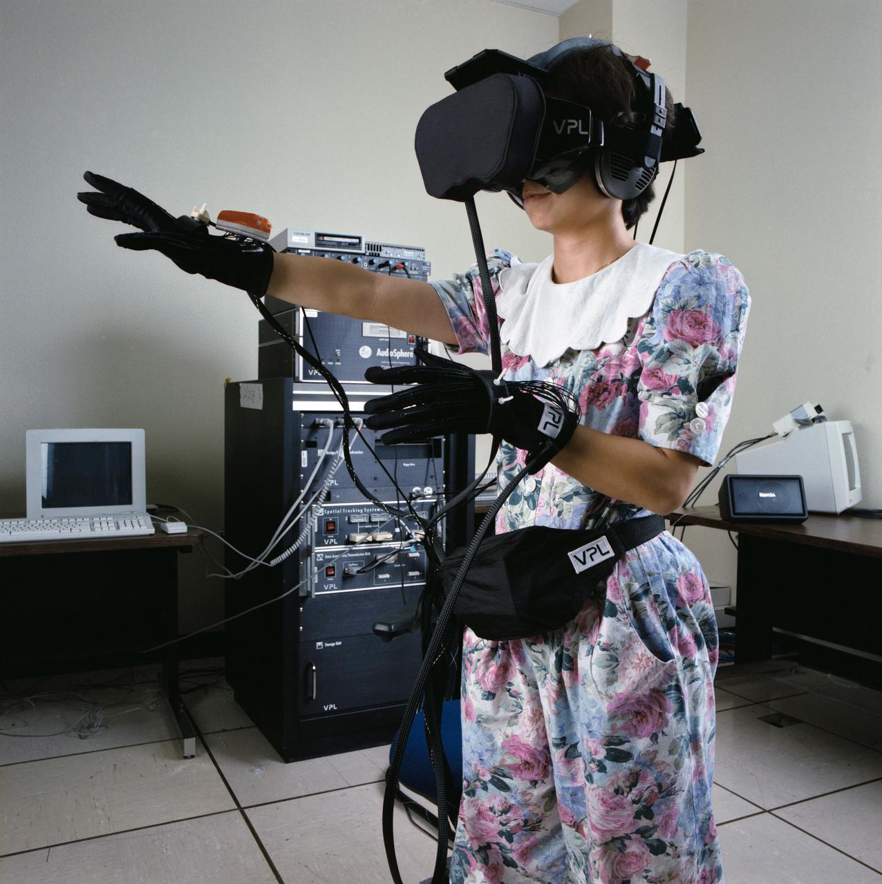 S91-50404 (1 Nov 1991) --- Bebe Ly of the Information Systems Directorate's (ISD) Software Technology Branch at the Johnson Space Center (JSC) gives virtual reality a try.  The stereo video goggles and head[phones allow her to see and hear in a computer-generated world and the gloves allow her to move around and grasp objects.  Ly is a member of the team that developed the C Language Integrated production System (CLIPS) which has been instrumental in developing several of the systems to be demonstrated in an upcoming Software Technology Exposition at JSC.