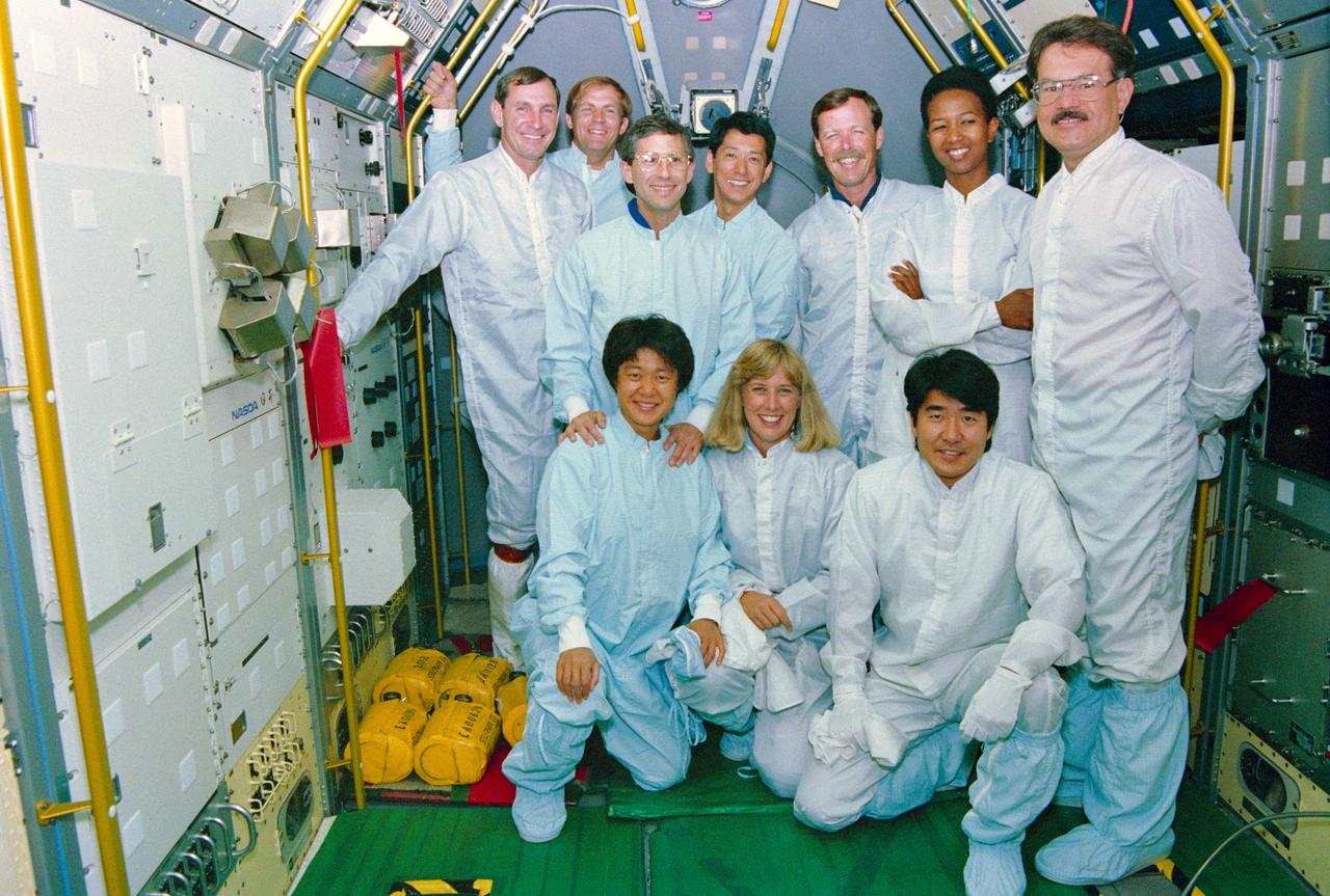 S92-44303 --- STS-47 Endeavour, Orbiter Vehicle (OV) 105, crew members and back-up payload specialists, wearing clean suits, pose for a group portrait in the Spacelab Japan (SLJ) module. The team is at the Kennedy Space Center's (KSC's) Orbiter Processing Facility (OPF) to inspect SLJ configuration and OV-105 preparations. Kneeling, from left, are back-up Payload Specialist Chiaki Naito-Mukai; Mission Specialist  N. Jan Davis; and backup Payload Specialist Takao Doi. Standing, from the left, are Pilot Curtis L. Brown,Jr;  Payload Commander Mark C. Lee;  Jerome Apt; Payload Specialist Mamoru Mohri; Commander Robert L. Gibson;  Mae C. Jemison; and back-up Payload Specialist Stanely L. Koszelak. Mohri, Mukai, and Doi represent the National Space Development Agency of Japan (NASDA). View provided by KSC with alternate KSC number KSC-92PC-1647. Photo credit: NASA
