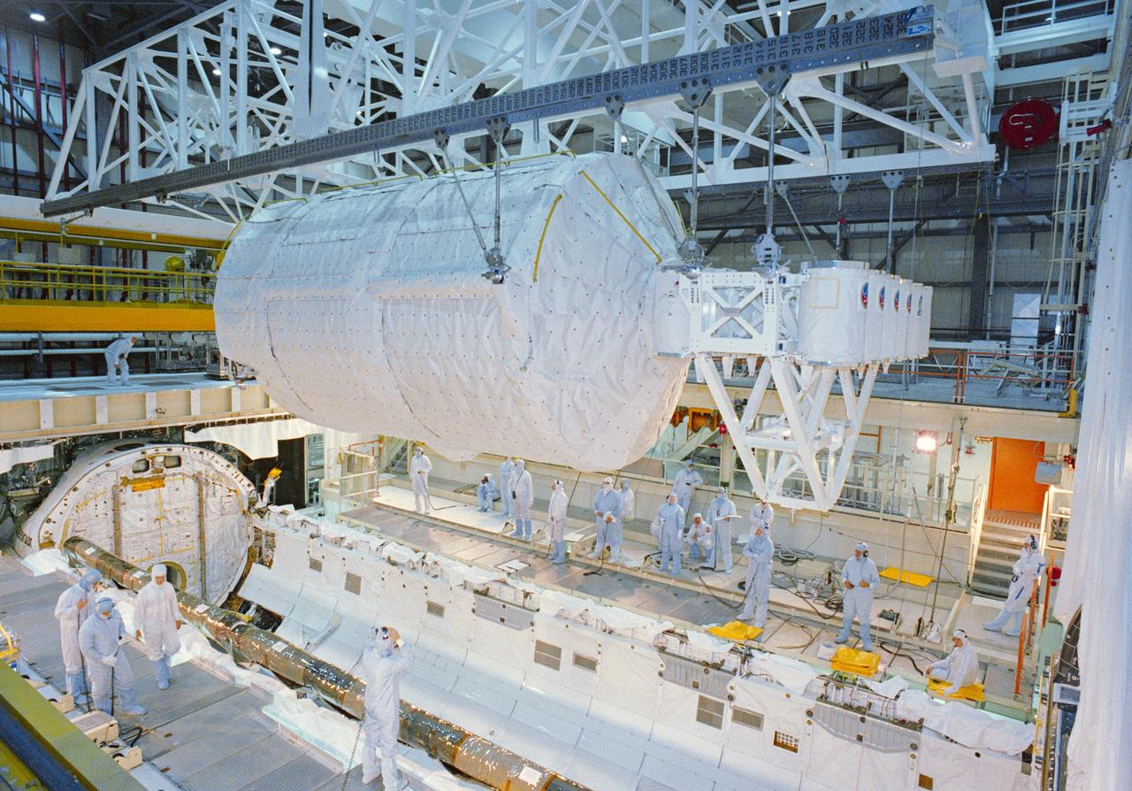 S92-44307 (25 July 1992) --- Technicians, engineers and flight crewmembers look on as the Spacelab-J laboratory module and experiment canister bridge are lowered into Endeavour's cargo bay. The STS-47 crewmembers visited Endeavour, currently undergoing pre-flight processing in a high bay area of the Orbiter Processing Facility at the Kennedy Space Center.  The Spacelab-J mission is currently scheduled for September of this year.
