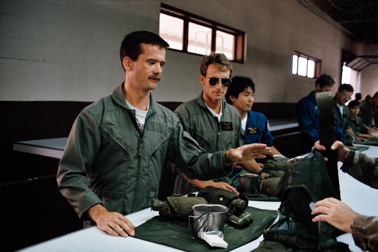 S92-46536 (16 Aug. 1992) --- Astronaut candidates Chris A. Hadfield, Jerry M. Linenger and Koichi Wakata (left to right in foreground) are issued gear for a survival school hosted by Fairchild Air Force Base.  Hadfield, from Canada, and Wakata, from Japan, are among the five international candidates in the group of astronaut candidates currently involved in a year-long training and evaluation program.