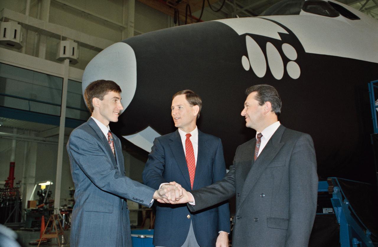 S92-49715 (10 Nov 1992) --- Russian cosmonauts Sergei Krikalev (left), and Vladimir Titov (right) share a team handshake with Kenneth L. Reightler, STS-60 pilot.  The cosmonauts toured the Space Shuttle mockup and integration laboratory, in which they will undergo a great deal of training in preparation for the mission.  One of the two will later be named as prime payload specialist and the second will serve as his alternate.  The six person crew, to be led by astronaut Charles F. Bolden, mission commander, will man the Space Shuttle Discovery for the scheduled eight-day flight.