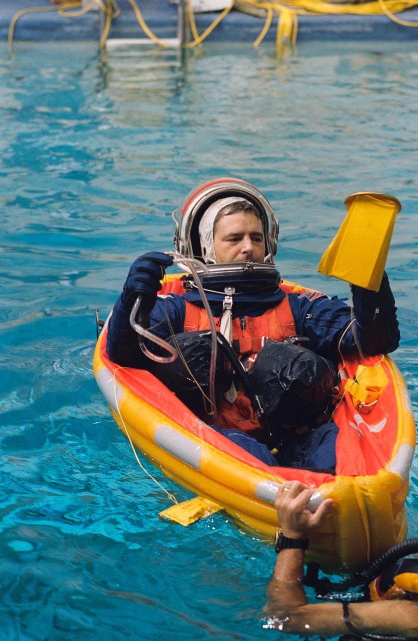 S93-45726 (7 Oct. 1993) --- Canadian astronaut candidate Marc Garneau, later named as a mission specialist for NASA's STS-77 mission, participates in emergency bailout training at the Johnson Space Center (JSC). Garneau was in the 1992 class of Astronaut Candidates (ASCAN).  Wearing full parachute gear following a simulated parachute drop, Garneau has deployed a small life raft in a 25-feet deep pool in JSC's Weightless Environment Training Facility (WET-F). This portion of an astronaut's training is to prepare him or her for proper measures to take in the event of bailout over water.  Garneau is assisted here by one of several SCUBA-equipped divers in the pool.