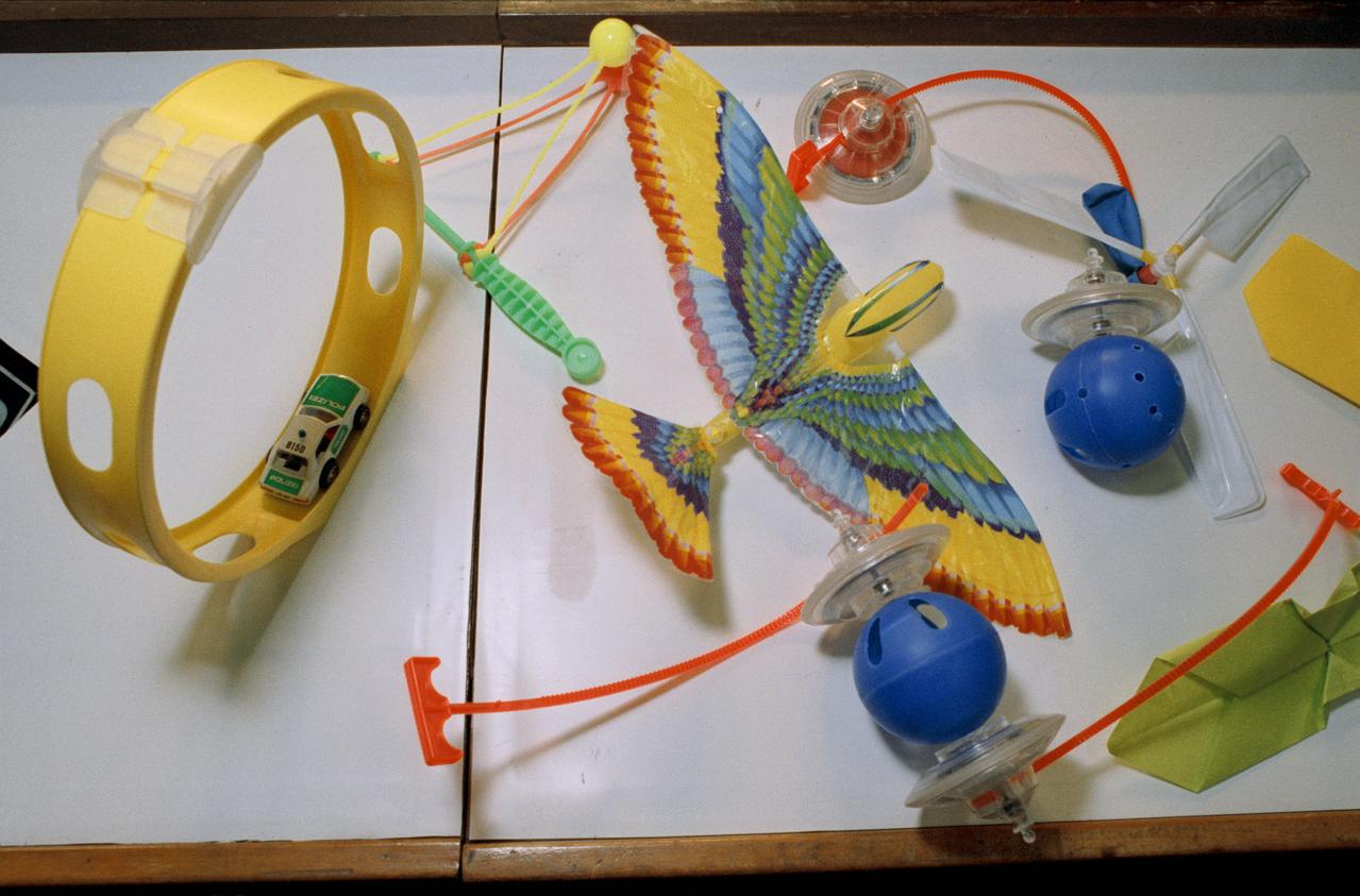 S93-25647 (6 Jan 1993) --- Part of the educational activities onboard the Space Shuttle Endeavour for STS-54 will include several experiments with various toys, some of which are depicted here.  The detailed supplementary objective (DSO-802) will allow the Shuttle crewmembers to experiment with the various types of toys in a microgravity environment while talking to pupils who will be able to monitor (via classroom TV sets) the activities at a number of schools. Among toys seen here are a friction car and loop track, paper eagle, and a balloon helicopter.